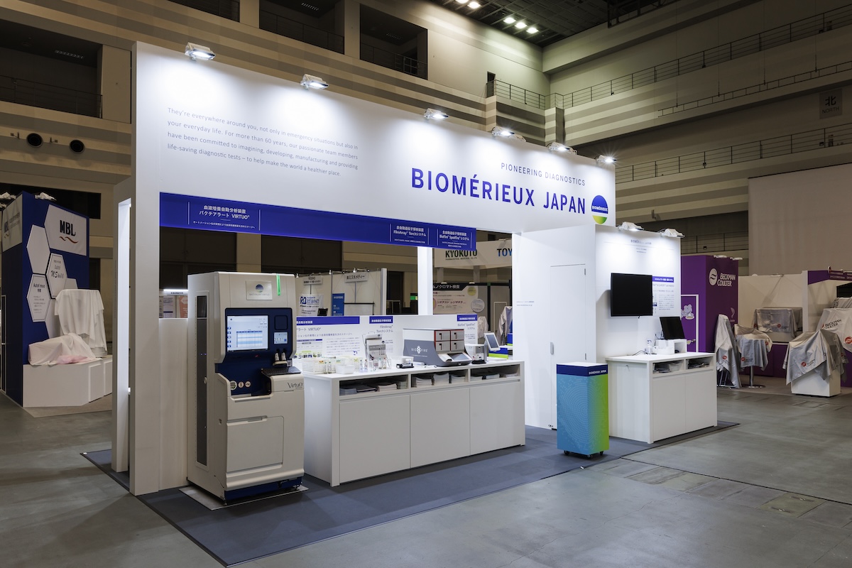 グリーンに青帯のキャスター付きカウンターがブース全体のアクセントに