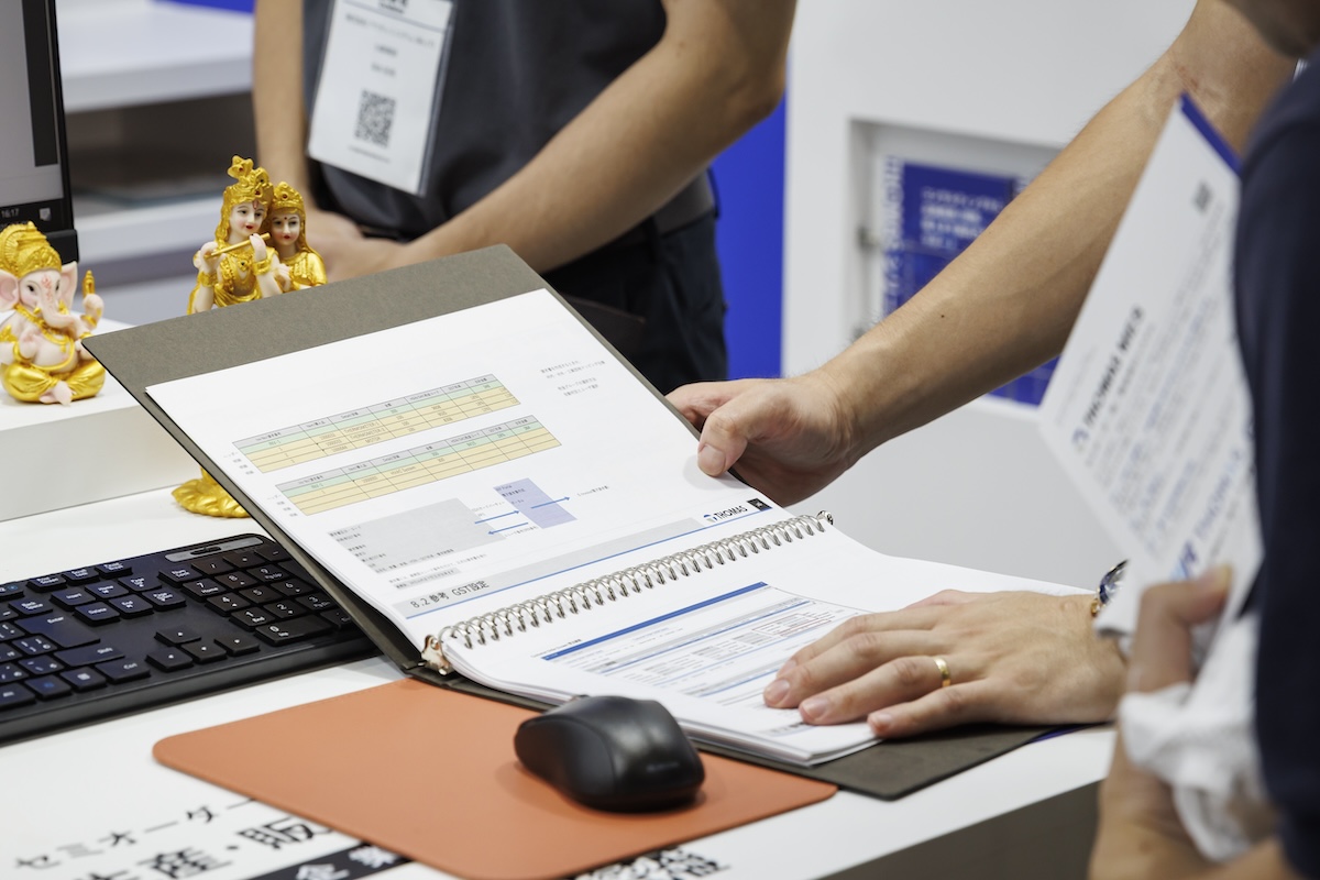 商談用展示台のモニターにパソコンを繋ぎ、PENGUINA4判バインダーを開いて説明