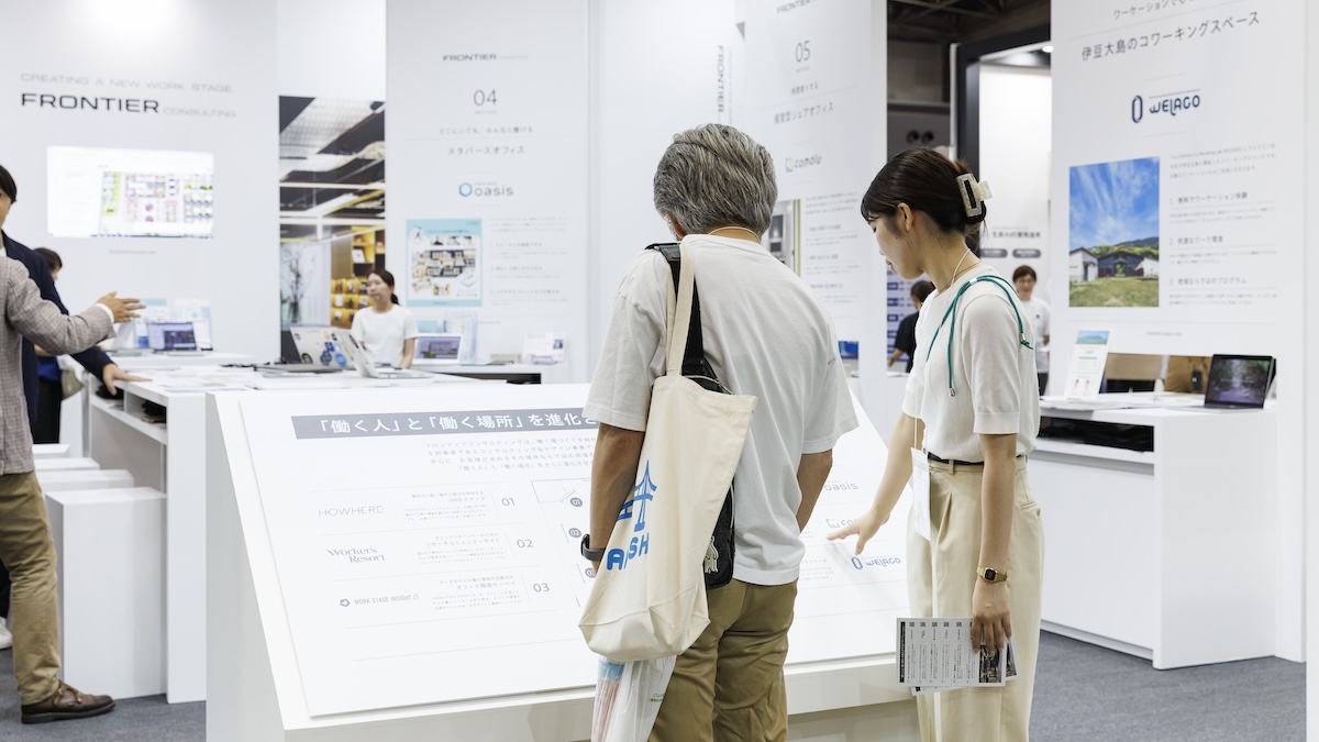 ブース正面のナビゲーションパネルでブース構成を把握しようとしている人々